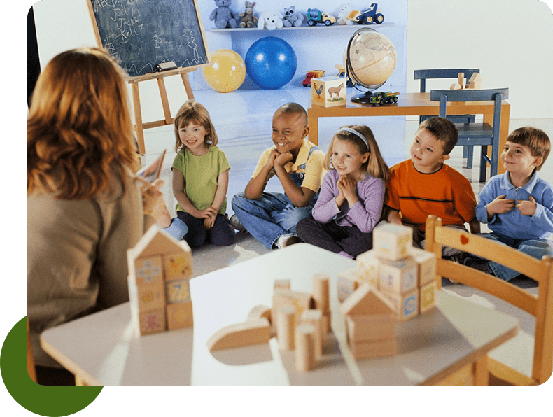 A group of children sitting in front of a teacher.