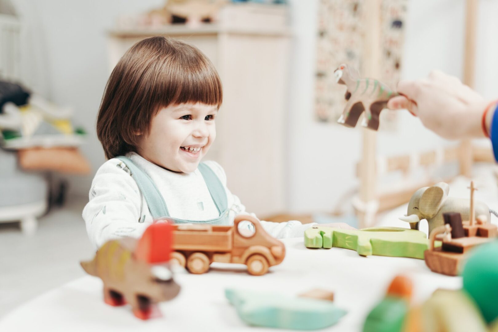 A child sitting at the table playing with toys.