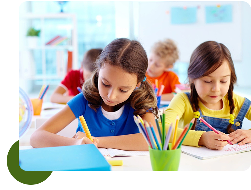 A group of children sitting at tables with pencils.