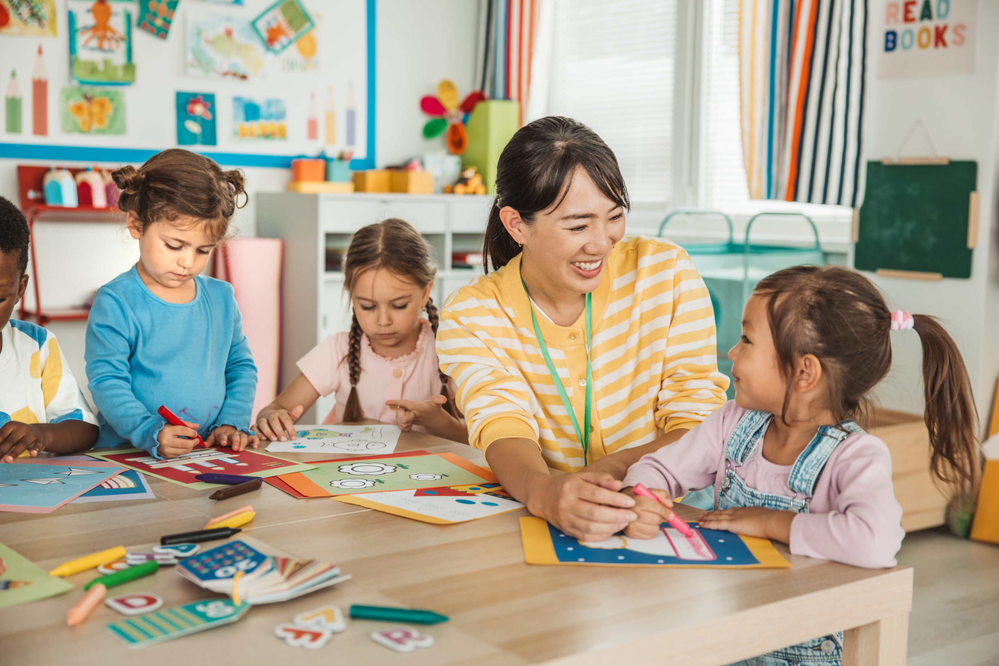 Teacher and children doing crafts in classroom
